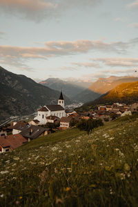 Houses on field by mountain against sky