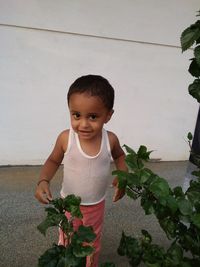 Portrait of baby boy standing against white wall