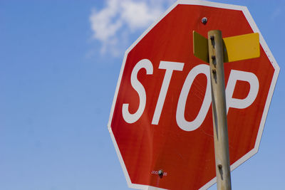 Low angle view of road sign against sky