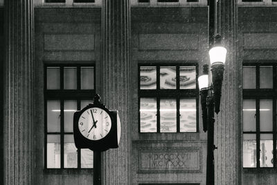 Close-up of illuminated clock hanging on wall