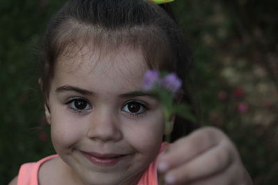 Close-up portrait of cute girl holding flower