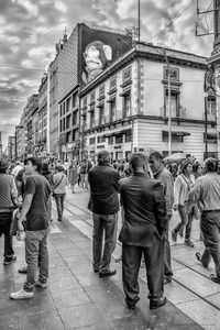 Rear view of people walking on street in city