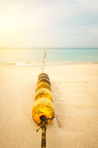 Yellow umbrella on beach against sky