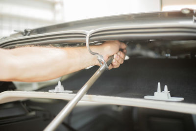 Cropped hand of mechanic repairing car