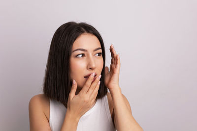 Portrait of young woman against white background