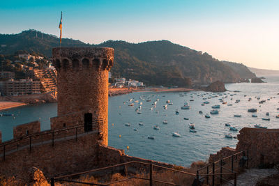 View of old building by sea against sky