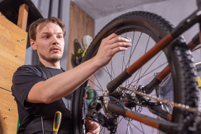 Low angle view of worker repairing bicycle