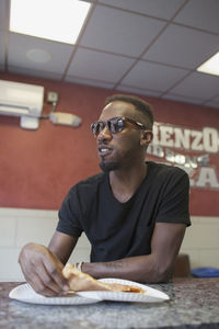 A young man eating pizza.