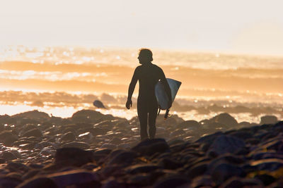 Rear view of silhouette man standing on beach