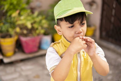 Close-up of boy eating lollipop outdoors