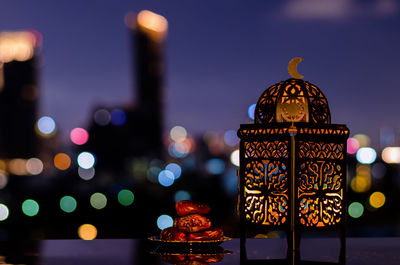 Lantern and small plate of dates fruit with night sky for the holy month of ramadan kareem.