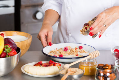 Midsection of chef preparing food in commercial kitchen