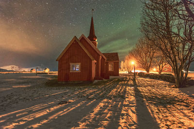 Church on illuminated field against sky at night