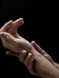 Close-up of woman hand against black background