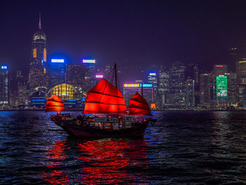 Boats in sea against sky at night