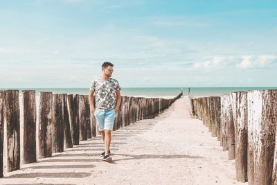Full length of man walking at beach against sky