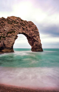 Rock formations on sea shore against sky