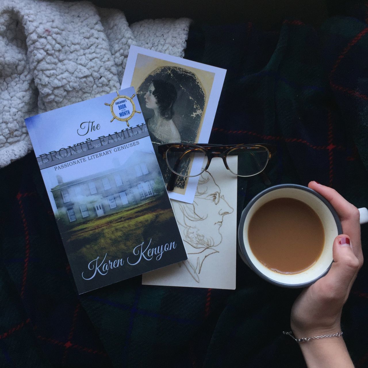 drink, cup, coffee, food and drink, mug, coffee cup, coffee - drink, refreshment, human hand, holding, hand, text, indoors, real people, communication, book, publication, table, one person, high angle view, tea cup, crockery, finger, non-alcoholic beverage