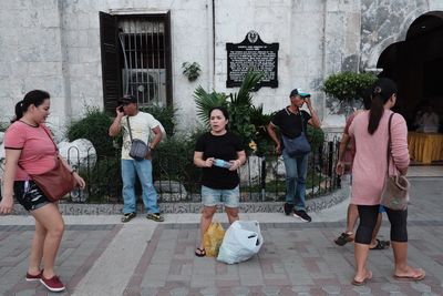 People standing on sidewalk in city