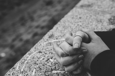 Cropped image of hands on retaining wall