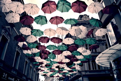Low angle view of multi colored umbrellas in city