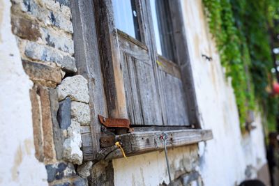 Low angle view of rusty window on wall