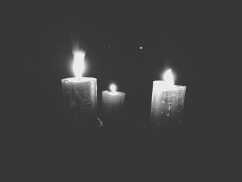 Close-up of illuminated candles in darkroom