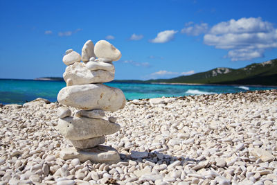 Stack of stones on beach against sky