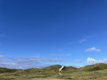 Scenic view of landscape against blue sky
