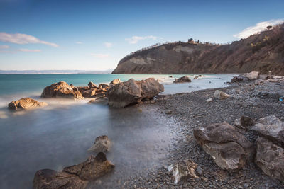 Rocks on sea shore against sky