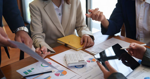 Midsection of business people working at office