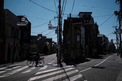 Cars on street in city against clear sky