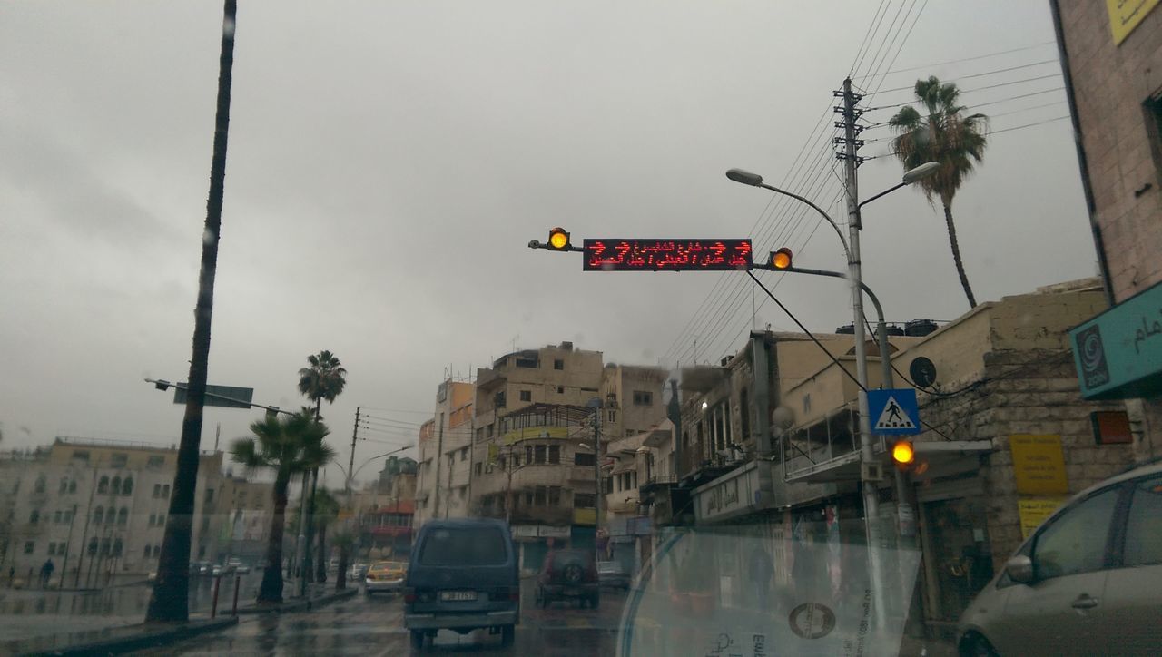 transportation, car, land vehicle, building exterior, architecture, built structure, street, mode of transport, text, road sign, road, city, communication, western script, information sign, city street, guidance, sky, street light, traffic