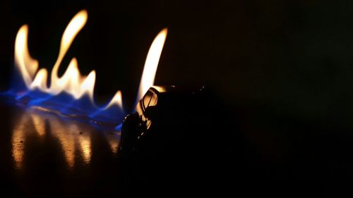 Close-up of lit candle in darkroom