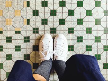 Low section of person standing on tiled floor