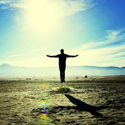 Silhouette man levitating above grassy field