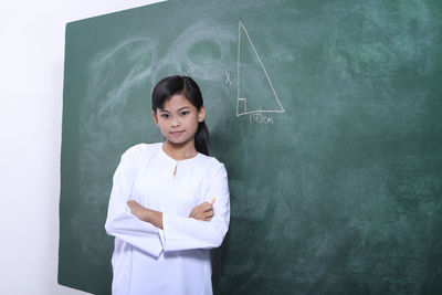 Portrait of girl against blackboard in school