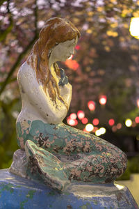 Close-up of angel statue against trees