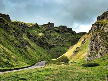 Scenic view of road amidst mountains against sky