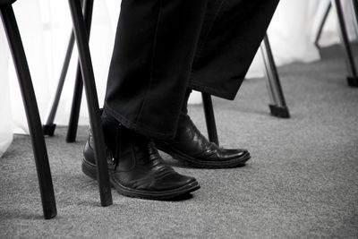 Low section of men standing on chair