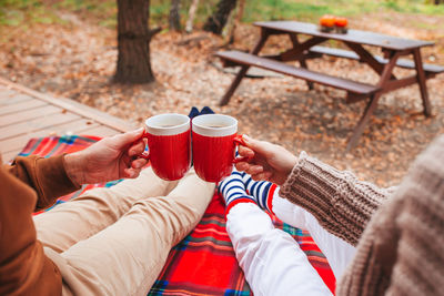 Low section of woman holding coffee cup