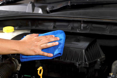 Cloth worker cleaning the car engine room