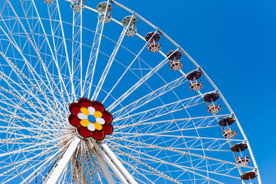 Low angle view of ferris wheel against clear blue sky