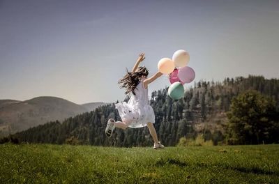Woman jumping on balloons