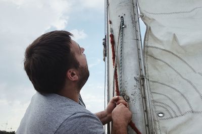 Rear view of man looking at camera against sky