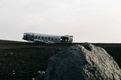 Abandoned airplane on field against sky