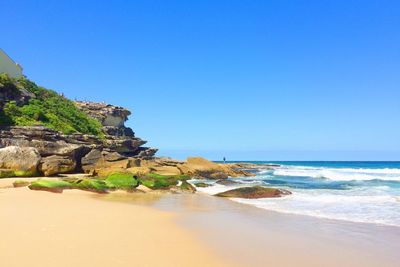 Scenic view of beach against clear blue sky