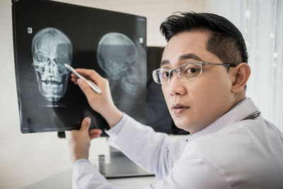 Portrait of doctor analyzing x-ray at hospital