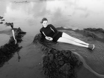 Portrait of young woman sitting in sea