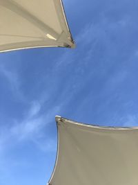 Low angle view of parasol against blue sky